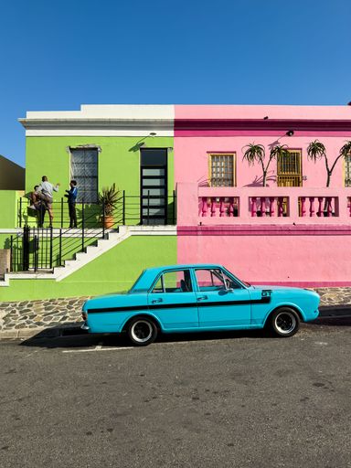 A vintage car parked in front of colourful houses in the historic Bo-Kaap neighbourhood of Cape Town
