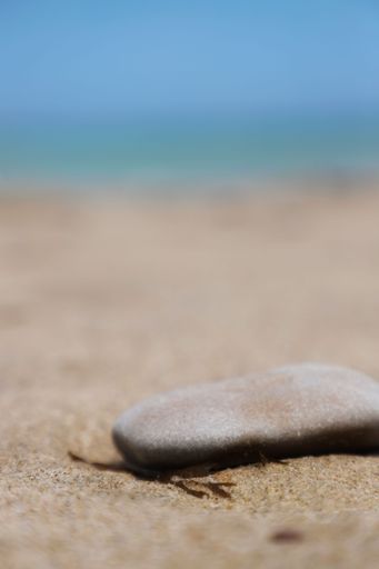 A closeup of smooth stone on top of the sand on the beach in Valencia,Spain