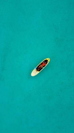 An aerial view of   model in paddle board Bacalar Mexico on a sunny day