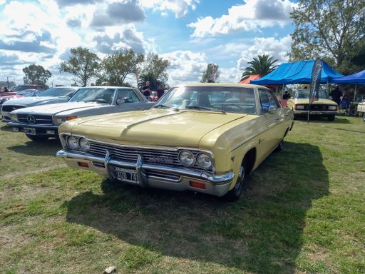 old 1966 Chevrolet Chevy Impala sedan by GM on the lawn. Nature, grass, trees. CAACMACH 2023 classic car show.