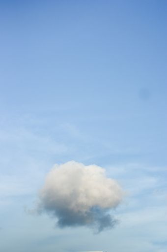 A vertical shot of a blue cloudy sky on a sunny day - great for wallpapers and backgrounds