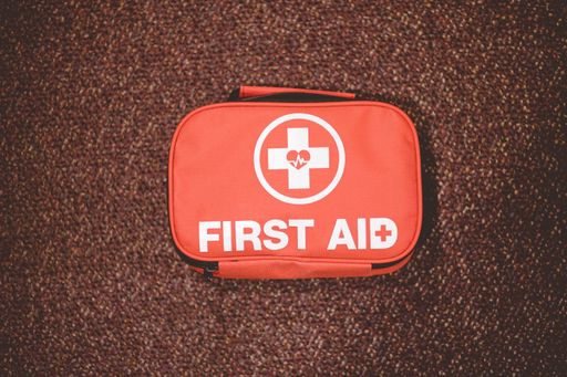 A closeup shot of a red first aid bag on a brown surface