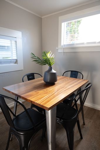 A contemporary dining room with a modern table and chairs set up in front of a window