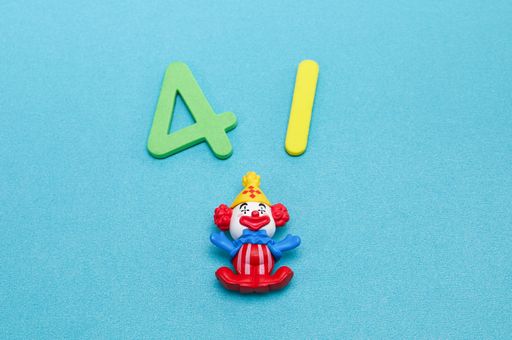 A clown figurine with numbers 4 and 1 isolated on blue background