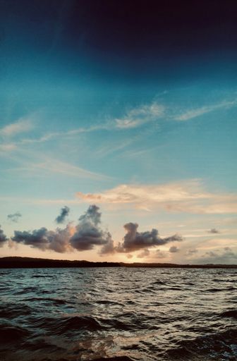 A vertical shot of the sea under the sunlight during the sunrise - perfect for wallpapers and backgrounds