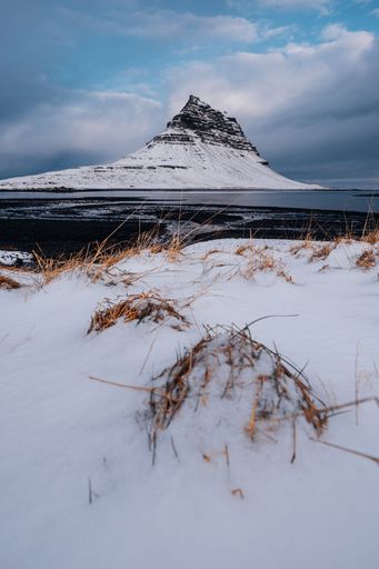 View of Reykjavik, Iceland from a snowy field, with a mountain in the distance