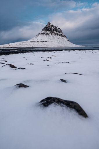 View of Reykjavik, Iceland from a snowy field, with a mountain in the distance