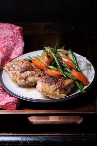 A vertical shot of chicken with rice and vegetables