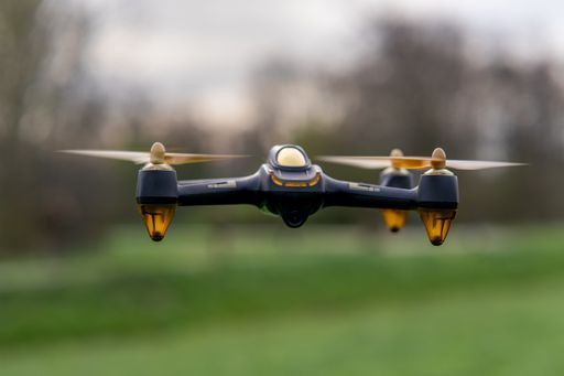 A closeup of a drone in a field under the sunlight with a blurry background