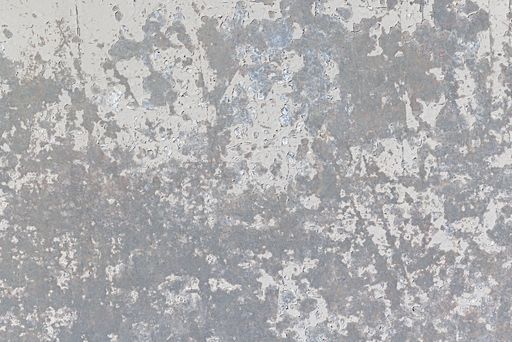 A concrete wall with a weathered finish and a faded grey paint color