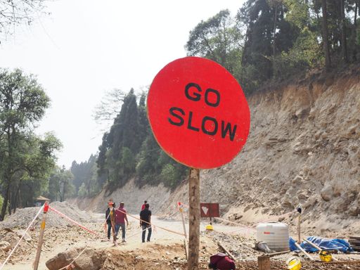 Go slow sign at mountain for road building