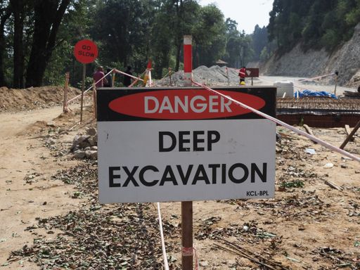Danger deep excavation sign at mountain for road building