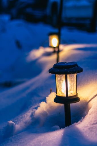 A vertical closeup shot of a street lump buried in the snow