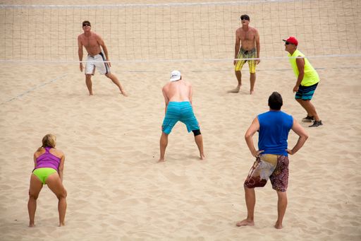 A group of people playing volleyball in a beach