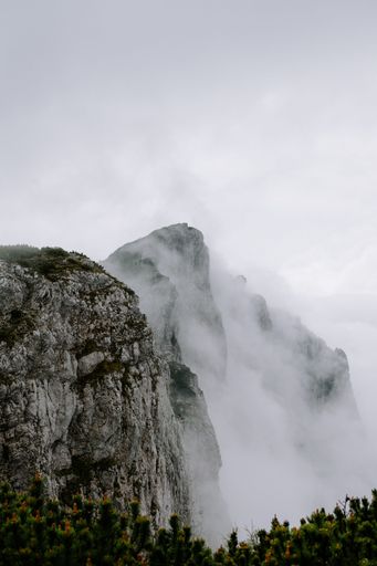 A scenic view of a majestic mountain shrouded in mist, creating a mysterious atmosphere