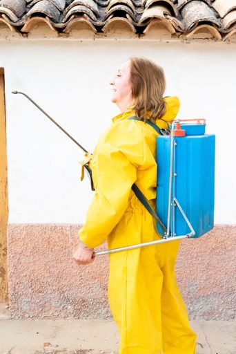 A vertical shot of a female wearing a chemical protective suit while using special tools