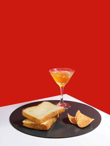 A vertical shot of appetizing snacks acccomponied with drinks isolated on red background
