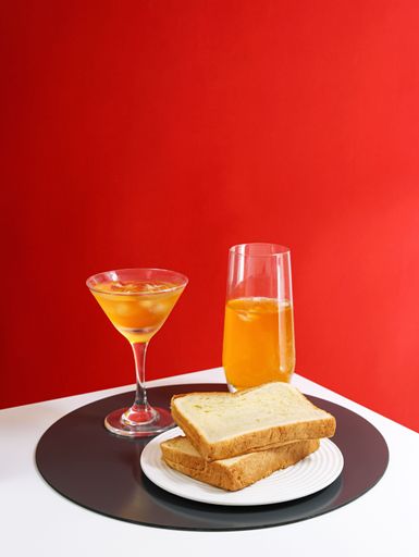 A vertical shot of appetizing snacks acccomponied with drinks isolated on red background