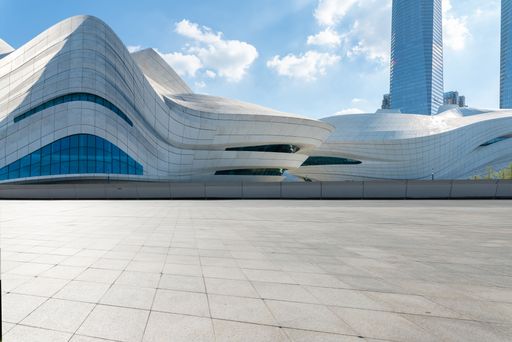 A modern white building with a city skyline in the background with skyscrapers