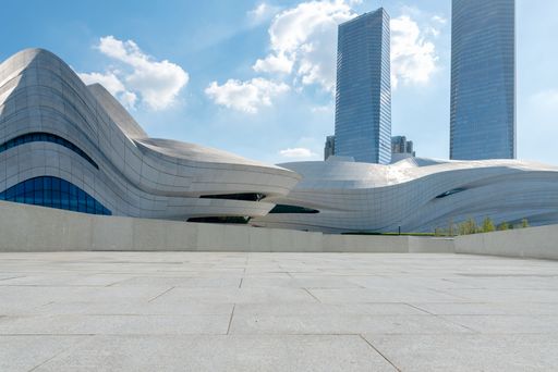 A modern white building with a city skyline in the background with skyscrapers