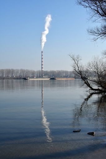 A vertical shot of heavy industry plant making smoke and steam damaging nature causing environmental pollution and global warming