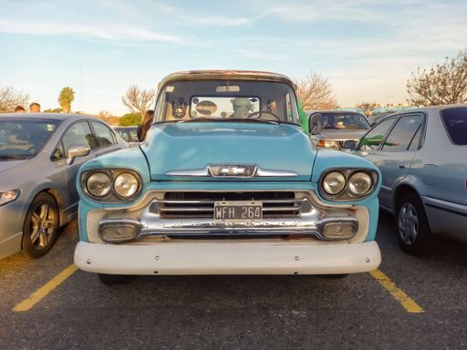 Old light blue utility 1958 Chevrolet Viking 60 pickup truck Task Force flareside bed by GM in a parking lot. Front view. Grille. Classic car show.