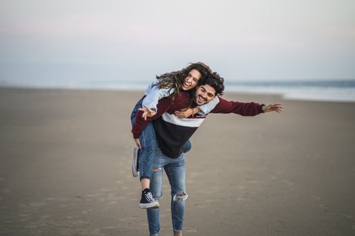 A selective focus shot of a happy Caucasian couple from Spain on the beach