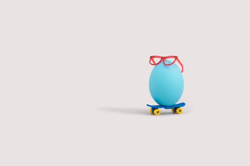 A blue egg with red glasses on a skateboard isolated on a white backgrou