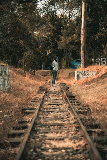 A woman walking through the rails in the middle of the forest