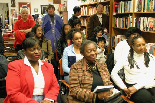 A diverse group of people in a library, surrounded by bookshelves filled with books and pictures