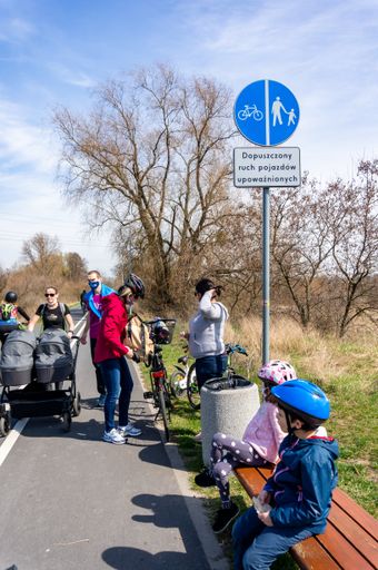 Kids and parents having a break during a bike trip on a route next to the Warta river. On of the first warm days in the spring season.