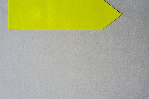 A yellow arrow-shaped sticker in the gray background with copy space in the bottom