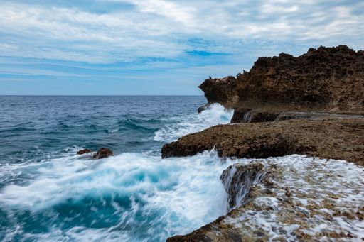 A view of Cape Zanpa, featuring a rocky shoreline and waves crashing against the shore