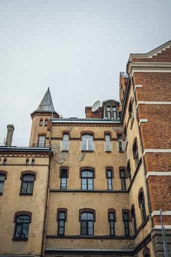 A low angle of a weathered old fashioned brown high rise building in the city