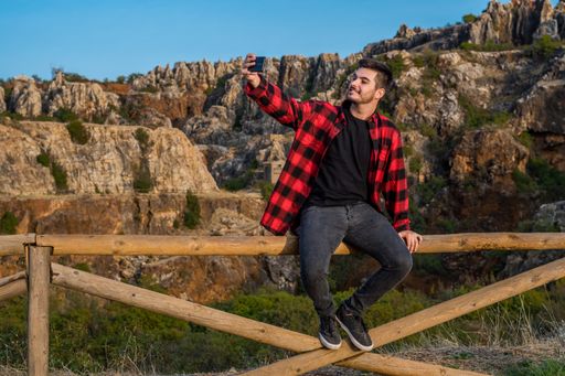 A young Caucasian man taking happy selfies in Sierra Norte Cazalla, Spain