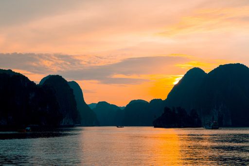 A beautiful wide shot of a lake with high hills and sunset behind with amazing clouds