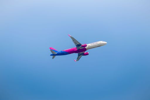 The Wizzair aeroplane flying in the blue sky