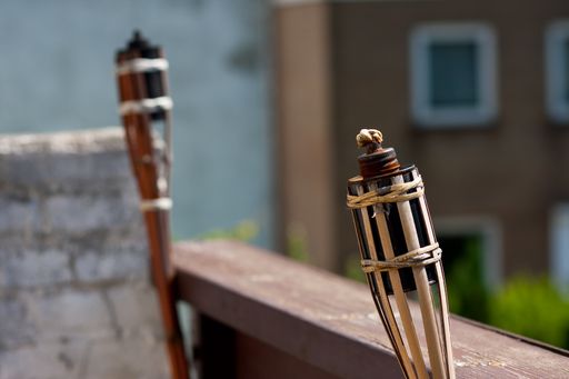 A wide angle shot of two unlit tiki torches next to each other on a building