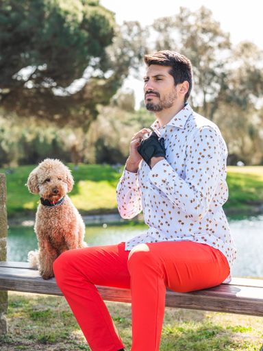 A young Caucasian male playing with his Goldendoodle dog on a professional golf course