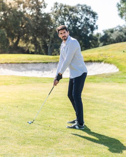 A young Caucasian male playing golf on a professional golf course