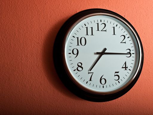 A closeup shot of a clock on a coral wall