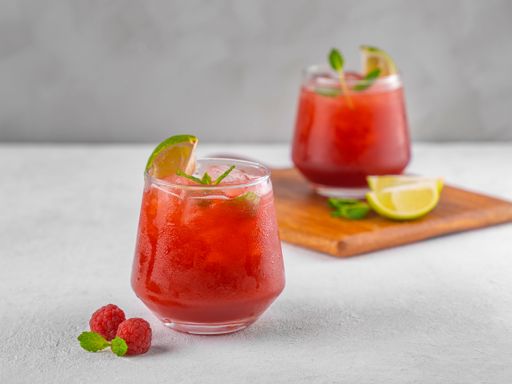 A closeup of two glasses of berry mojito