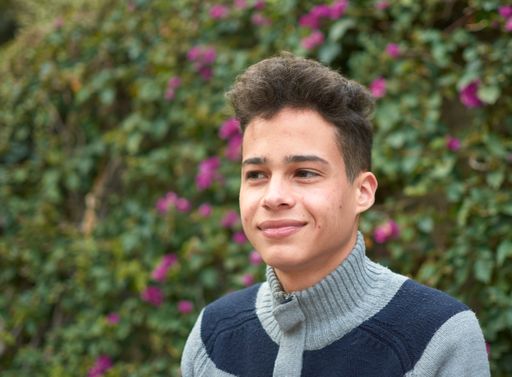 A portrait of a happy Hispanic male in the park