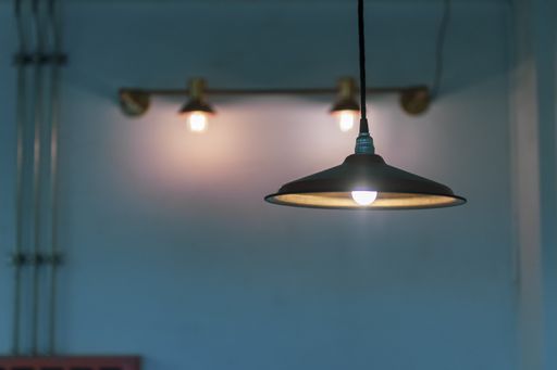 a selective focus shot of illuminated lamps hanging from the ceiling in a blue room