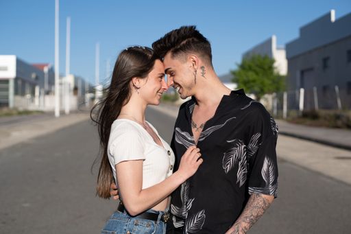 A beautiful shot of a Caucasian couple facing each other while hugging in the street