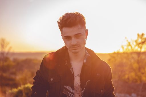 A beautiful shot of a Caucasian man during the sunset looking at the camera