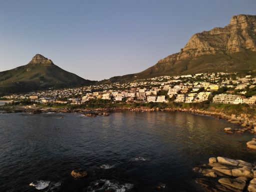 A scenic view of houses on the slope of Devi's peak in Camps Bay, South Africa at sunset