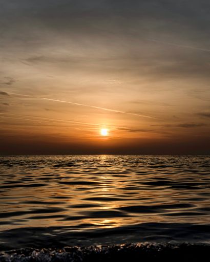 A breathtaking sunset view of the ocean beach as the sun sets, creating a stunning silhouette of the shoreline