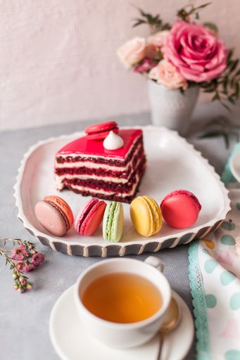 A closeup of tasty sweets on the table served with tea and arranged with flowers