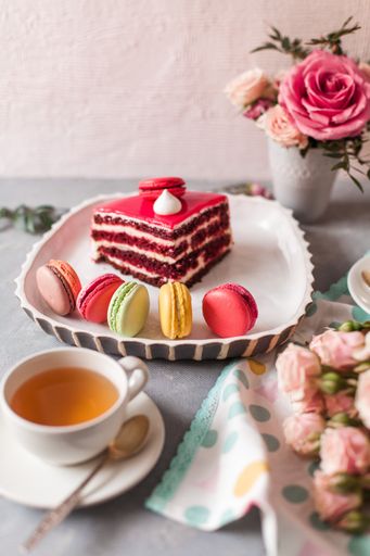 A closeup of tasty sweets on the table served with tea and arranged with flowers